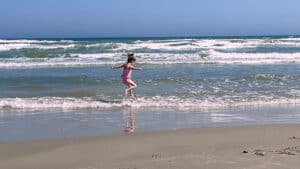 Winry jumping over the waves on the Texas coast.
