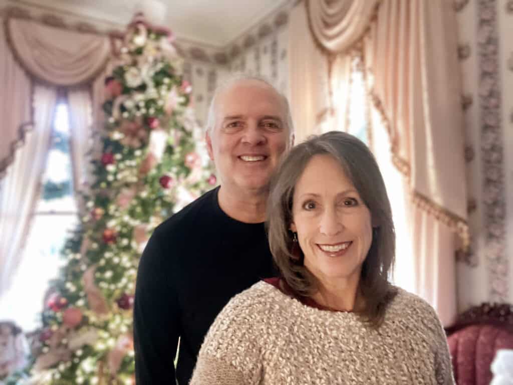 Scot and Jessica standing in front of a beautiful Christmas tree and decor of a bed and breakfast where they stayed in Natchitoches, Louisiana.